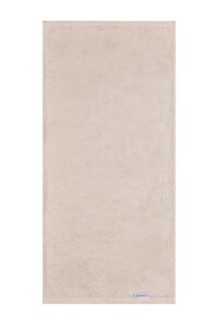 De Beddinghouse Care-handdoek in beige ziet er heerlijk zacht en volumineus uit, met een subtiel stoffen label aan de rand.