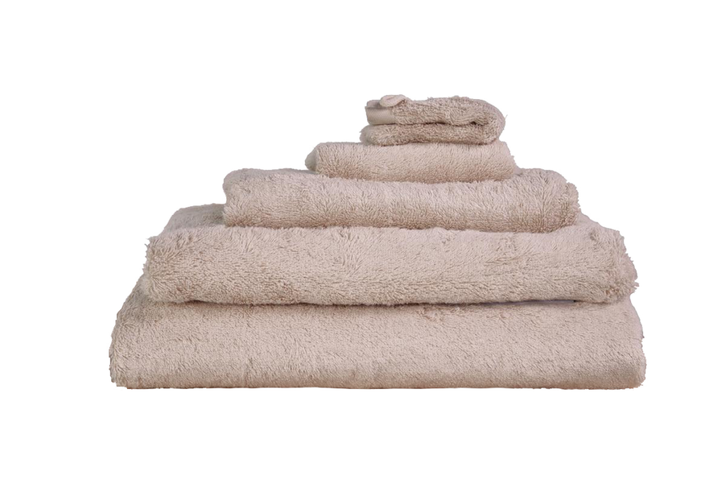 Een zorgvuldig opgestapelde set Beddinghouse Care-badhanddoeken in beige ligt op volgorde van groot naar klein.