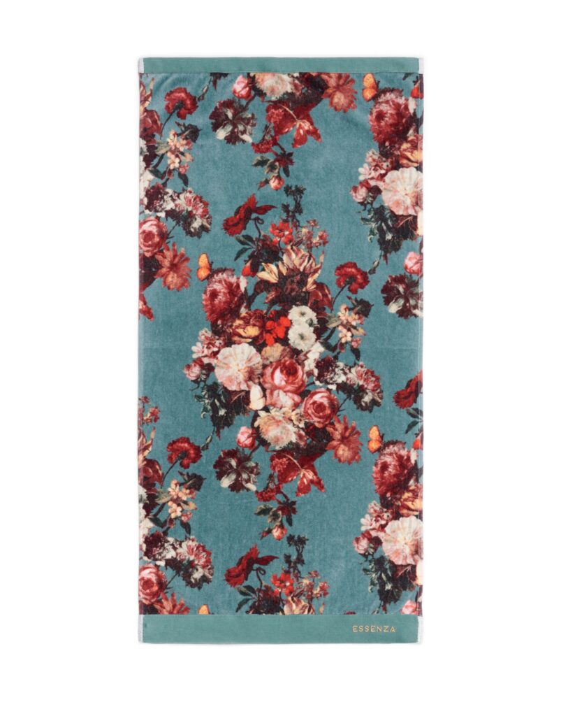 De Essenza Karli gastendoek in rifgroen is een rechthoekige handdoek in blauwgroen met kleurrijke bloemen, oranje vlinders en een gouden logo.