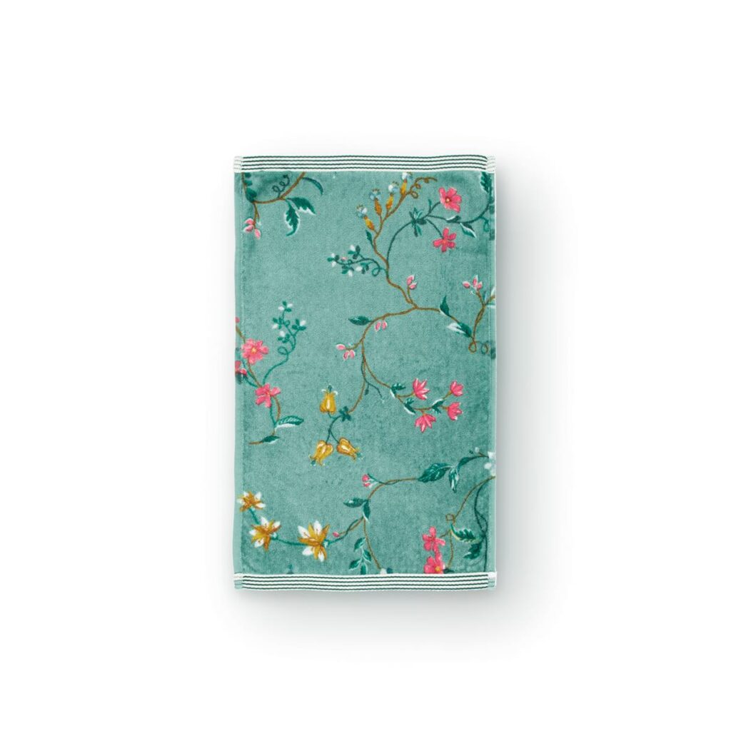 Drie opgevouwen Pip Studio Les Fleurs gastendoekjes in groenblauw met bloemen in roze, geel en wit en groene bladeren.