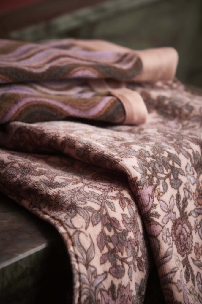 De Essenza Ophelia-handdoek Darling in roze heeft een subtiel bloemenpatroon in roze, bruin en paars en benadrukt de zachte textuur.