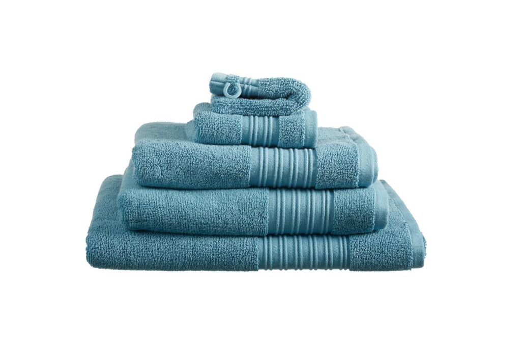 Drie netjes opgestapelde Beddinghouse Sheer Gastendoek Blauw-handdoeken lopen van groot naar klein.