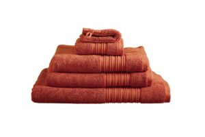 Vier roestkleurige handdoeken, waaronder de Beddinghouse Sheer Gastendoek Oranje, liggen netjes opgestapeld van klein naar groot.