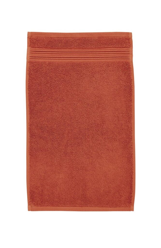 De Beddinghouse Sheer Gastendoek Oranje-set bestaat uit drie netjes opgevouwen rechthoekige handdoeken met een sierlijke rand.