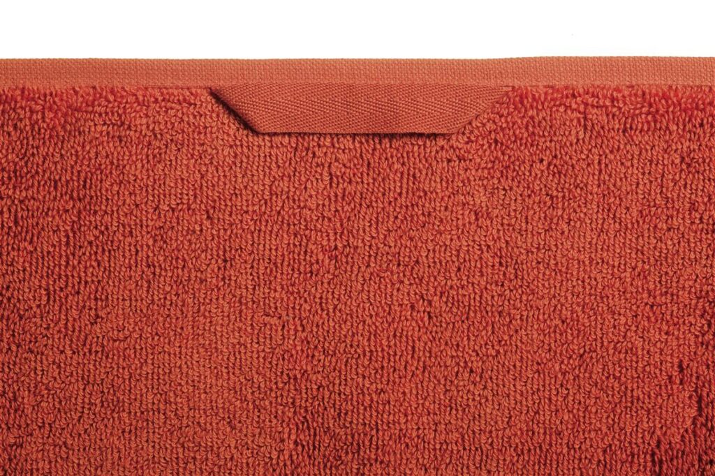 De Beddinghouse Sheer Gastendoek Oranje-set bestaat uit rood, gestructureerd textiel met bijpassende afwerking en een ophanglusje.