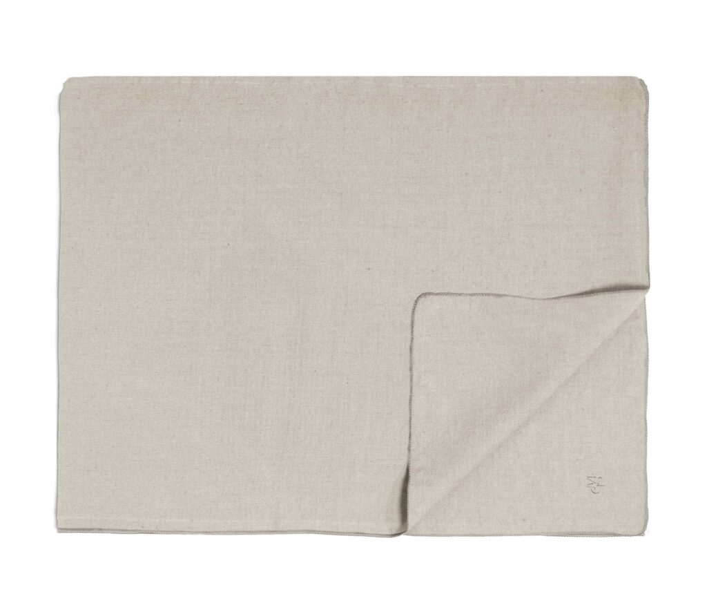 Het Marc O'Polo Valka-tafelkleed in Oatmeal is een lichtbeige tafelkleed met een nette vouw en subtiele plooitjes.