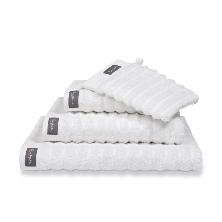 Een stapel Vandyck Home Wave Badlaken White-handdoeken met een donker label, netjes op volgorde van klein naar groot.