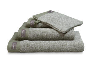 De Vandyck Home Mouline-badhanddoek Olive met een label aan de rand wordt netjes en overzichtelijk gepresenteerd.
