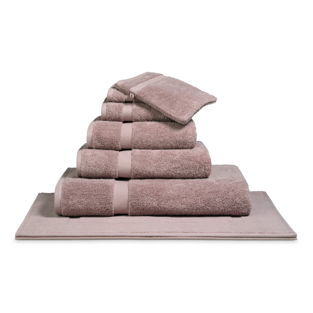 Het De Vandyck Ranger-badlaken in de kleur mauve ligt netjes opgestapeld en straalt luxe uit.