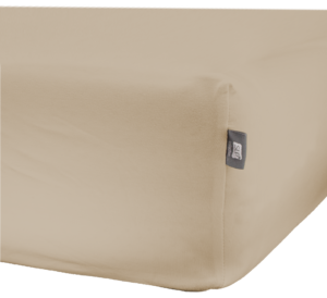 Het SLP Jersey-hoeslaken in ivoorwit heeft een beige uitstraling en een grijs label in de zijnaad, dat strak om de hoek van het matras zit.