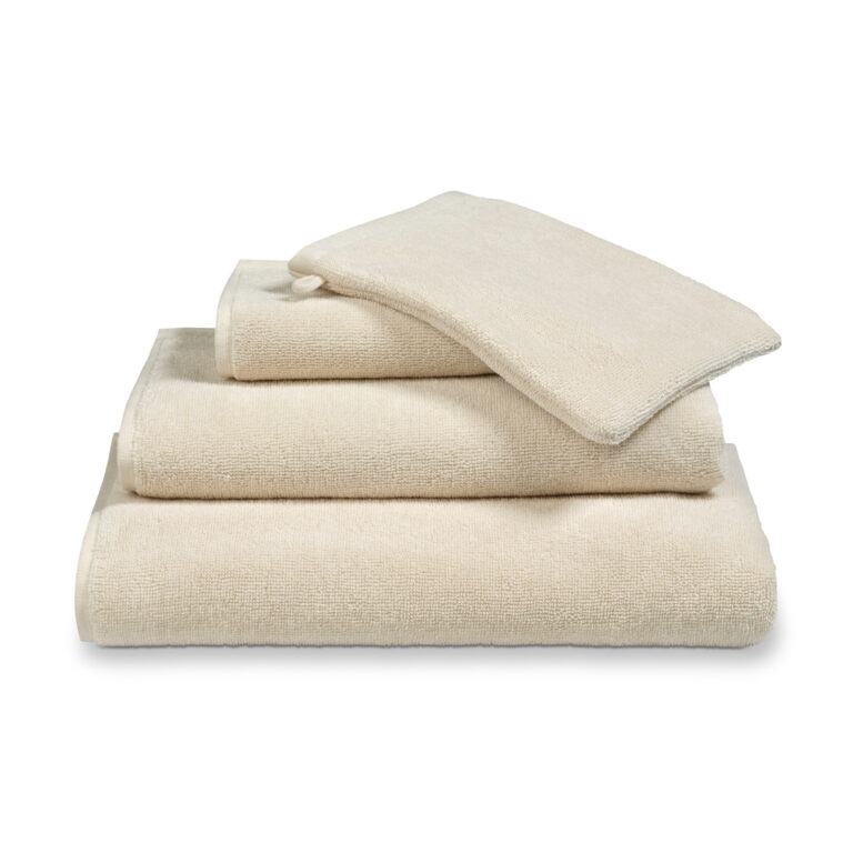 Een netjes gestapelde set Vandyck Verona Plain Badlaken Desert-handdoeken, bestaande uit twee grote handdoeken, een kleine handdoek en een washandje.