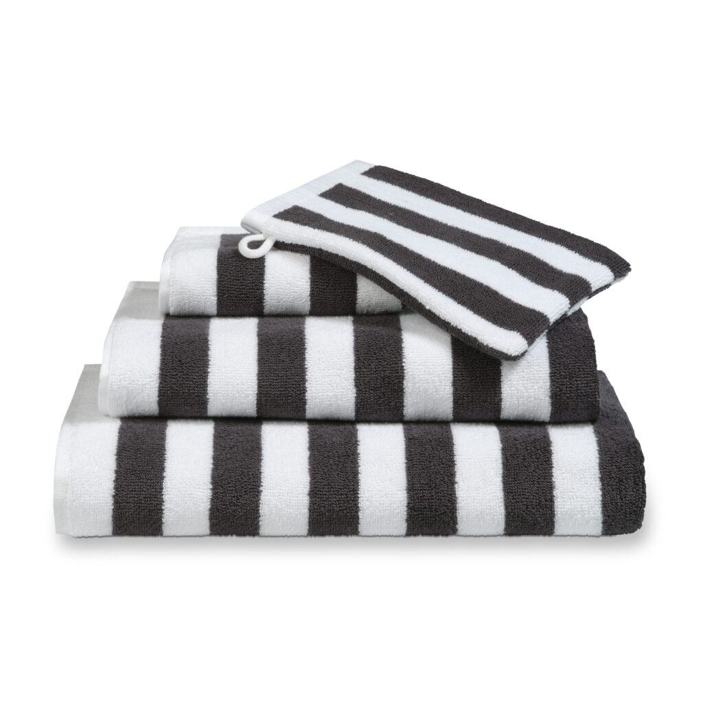 De Vandyck Verona Stripes Badlaken Smoke green is netjes opgestapeld en heeft opvallende zwarte en witte strepen op elke handdoek.