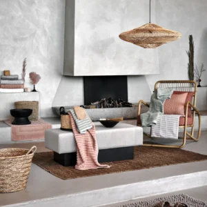 In deze moderne woonkamer zorgt het Vandyck Home Wave-badlaken in de kleur Smoke Green voor een zachte toets in het natuurlijke interieur.