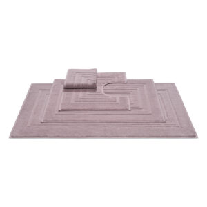 Onderin ligt een Vandyck Houston badmat in mauve, met daaronder twee bijpassende badmatten in kleinere maten, waarvan de kleinste een U-vormige uitsparing heeft die perfect om het toilet past.