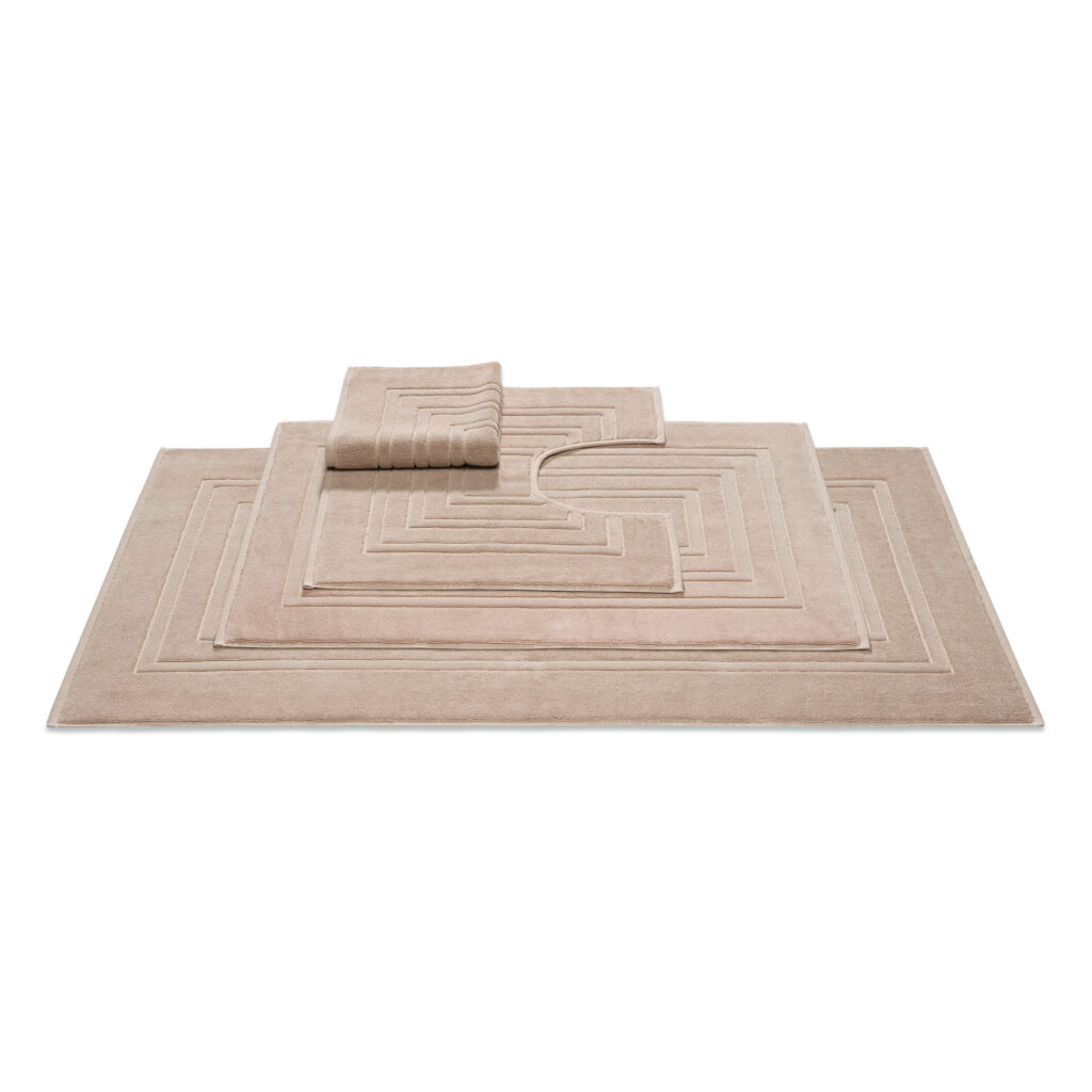 De Vandyck Houston badmat Almond is een beige badmat met een modern geometrisch patroon, gecombineerd met bijpassende matten.