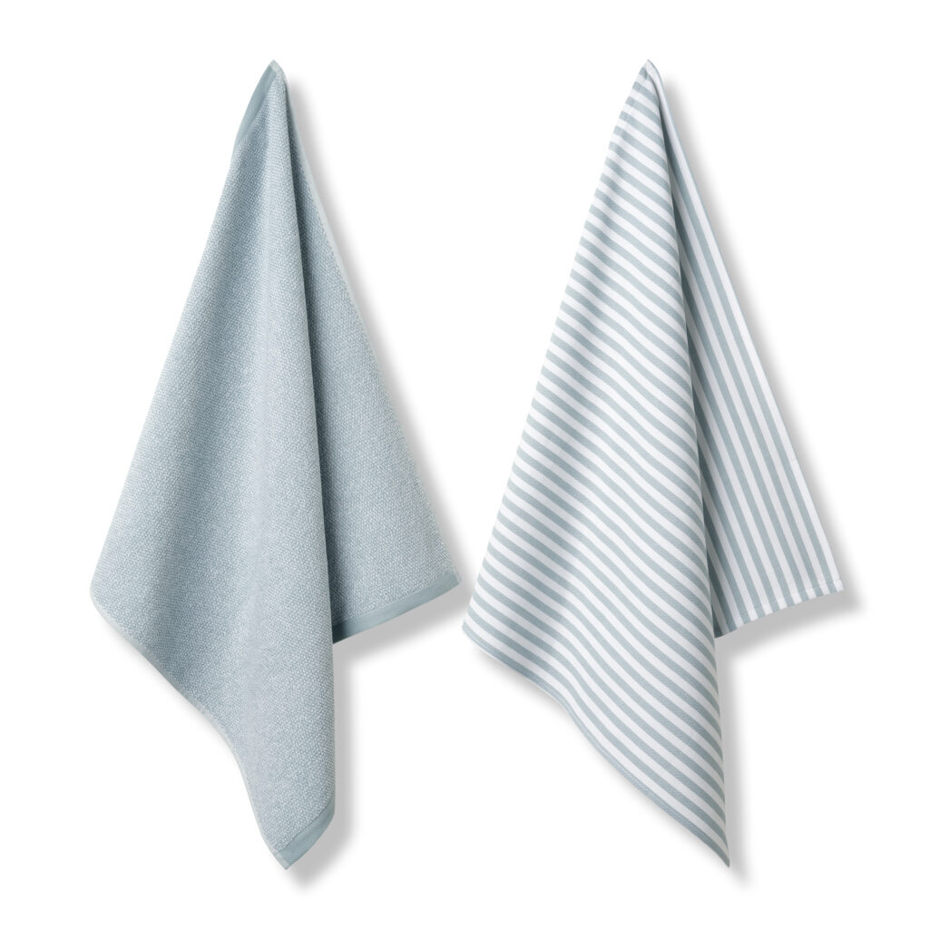 De Vandyck Pure keukenset Pearl Blue bestaat uit twee theedoeken: één in effen lichtblauw en één met witte en lichtblauwe strepen.