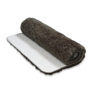 De opgerolde Vandyck Toronto badmat in donkergrijs, met een shaggy structuur en een witte antislip-achterkant, ligt klaar.