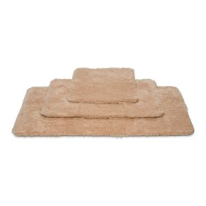 De Vandyck Toronto Badmat Praline ligt bovenop een stapel beige rechthoekige matten van verschillende afmetingen.