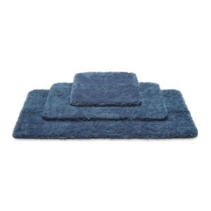 De Vandyck Toronto badmat Vintage Blue ligt in een stapel met twee andere blauwe badmatten in verschillende maten.