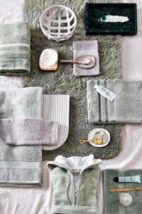 De Vandyck Prestige-handdoekenset in lichtolijfgroen past perfect bij het zachtgroene en lavendelkleurige badtextiel en de bijbehorende accessoires.