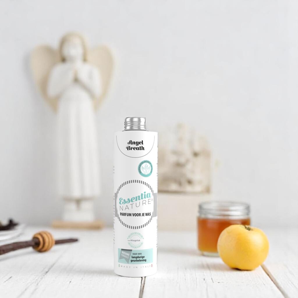 Essentia Wasparfum Angel Breath 250 ml wordt omringd door een engelenbeeldje, honing, citroen en een vanillestokje op de achtergrond.