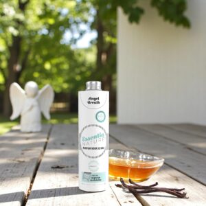 Op een houten tafel buiten staat een flesje Essentia Wasparfum Angel Breath naast een schaaltje, vanillepeulen en een engelenbeeldje.