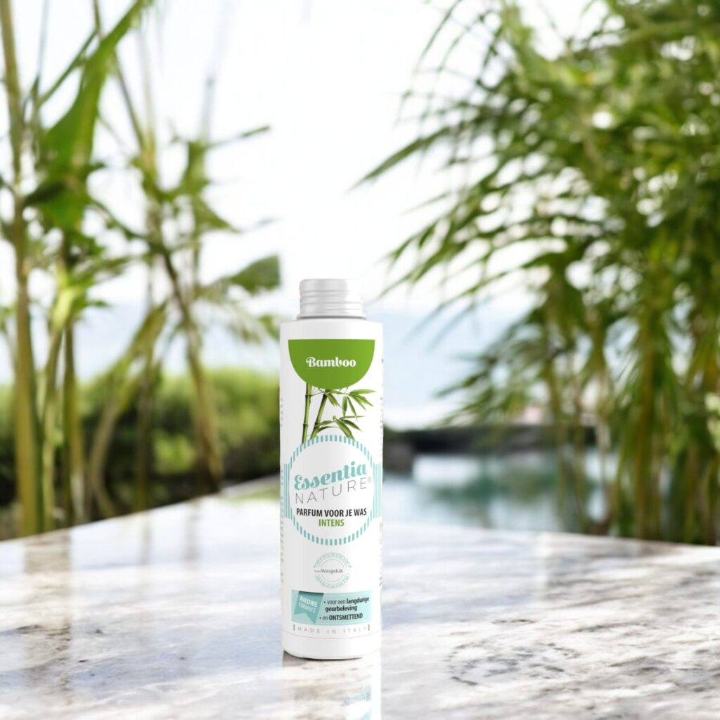 Essentia Wasparfum Bamboo 250 ml staat buiten op een marmeren oppervlak tussen groene bamboestruiken bij een kabbelend waterornament.