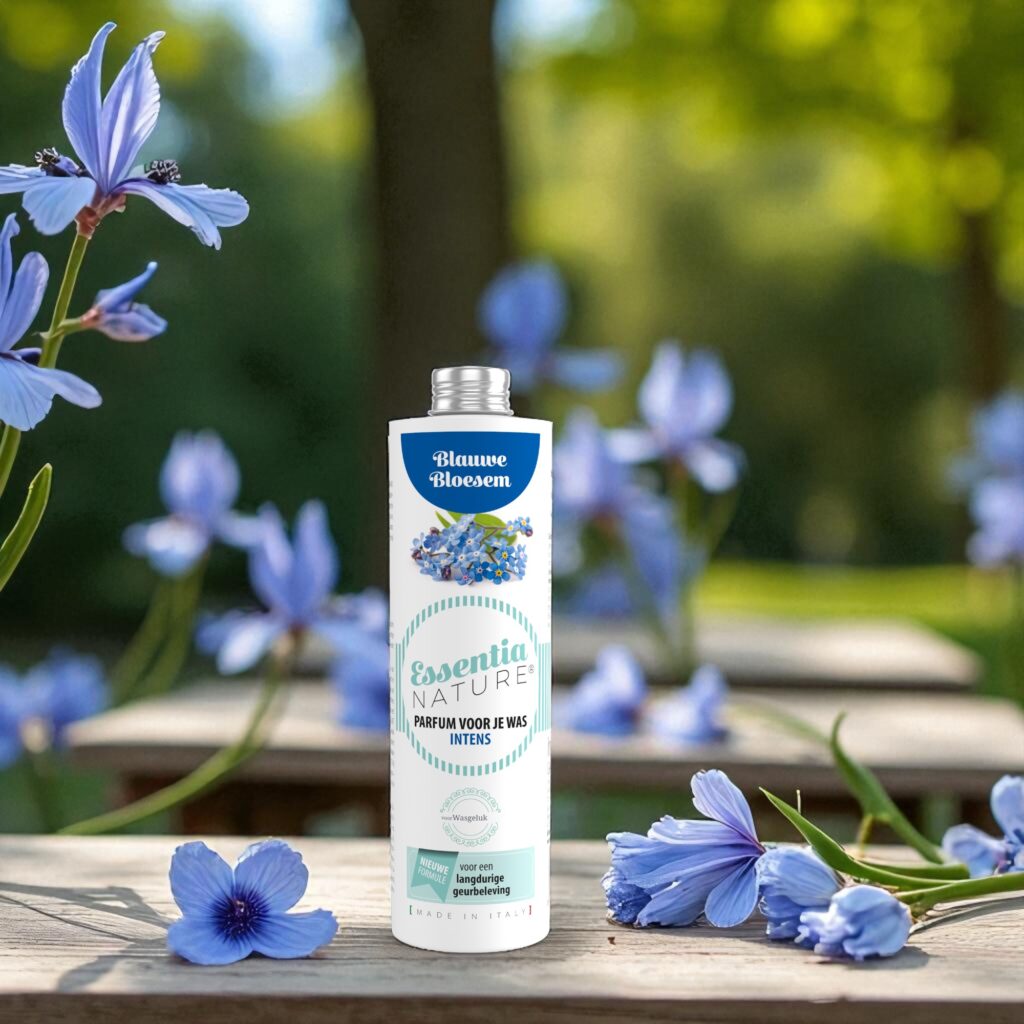 Essentia Wasparfum Blauwe Bloesem 250 ml staat buiten op een houten plank, omringd door blauwe bloemen en groen in zacht zonlicht.