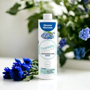 Essentia Wasparfum Blauwe Bloesem toont verse blauwe bloemen met zacht vervaagde groene bladeren op de achtergrond.