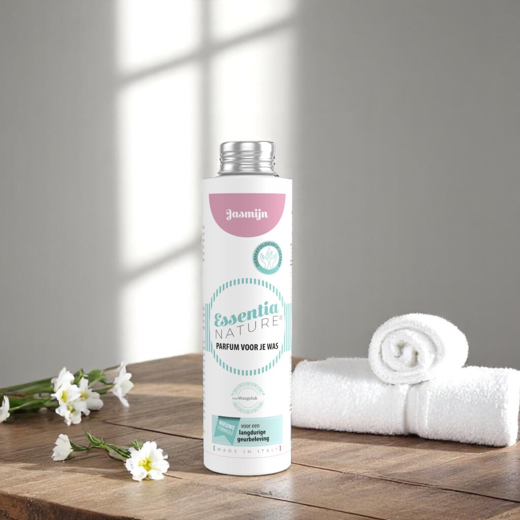 Essentia Wasparfum Jasmijn 250 ml staat op een houten oppervlak naast een opgerolde witte handdoek en bloemen in zacht zonlicht.