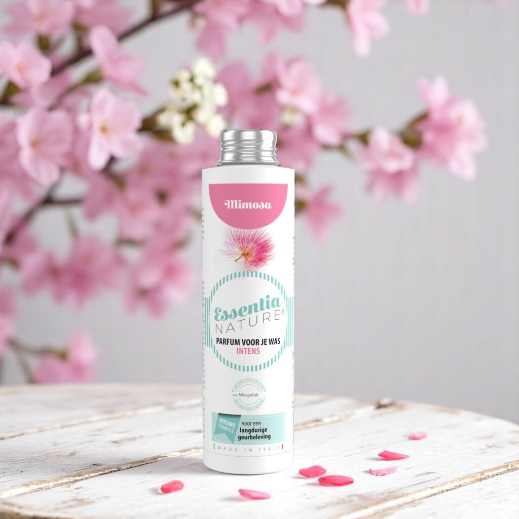 Essentia Wasparfum Mimosa 250 ml ligt tussen roze mimosa-bloemen en -blaadjes, met een pastelkleurig etiket vol bloemenprint.