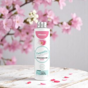 Essentia Wasparfum Mimosa 250 ml ligt tussen roze mimosa-bloemen en -blaadjes, met een pastelkleurig etiket vol bloemenprint.