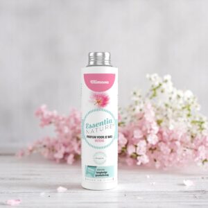 De Essentia Wasparfum Mimosa 250 ml, met pastelkleuren en mimosa-bloemen, steekt af tegen de achtergrond van zachtroze en witte bloemen.