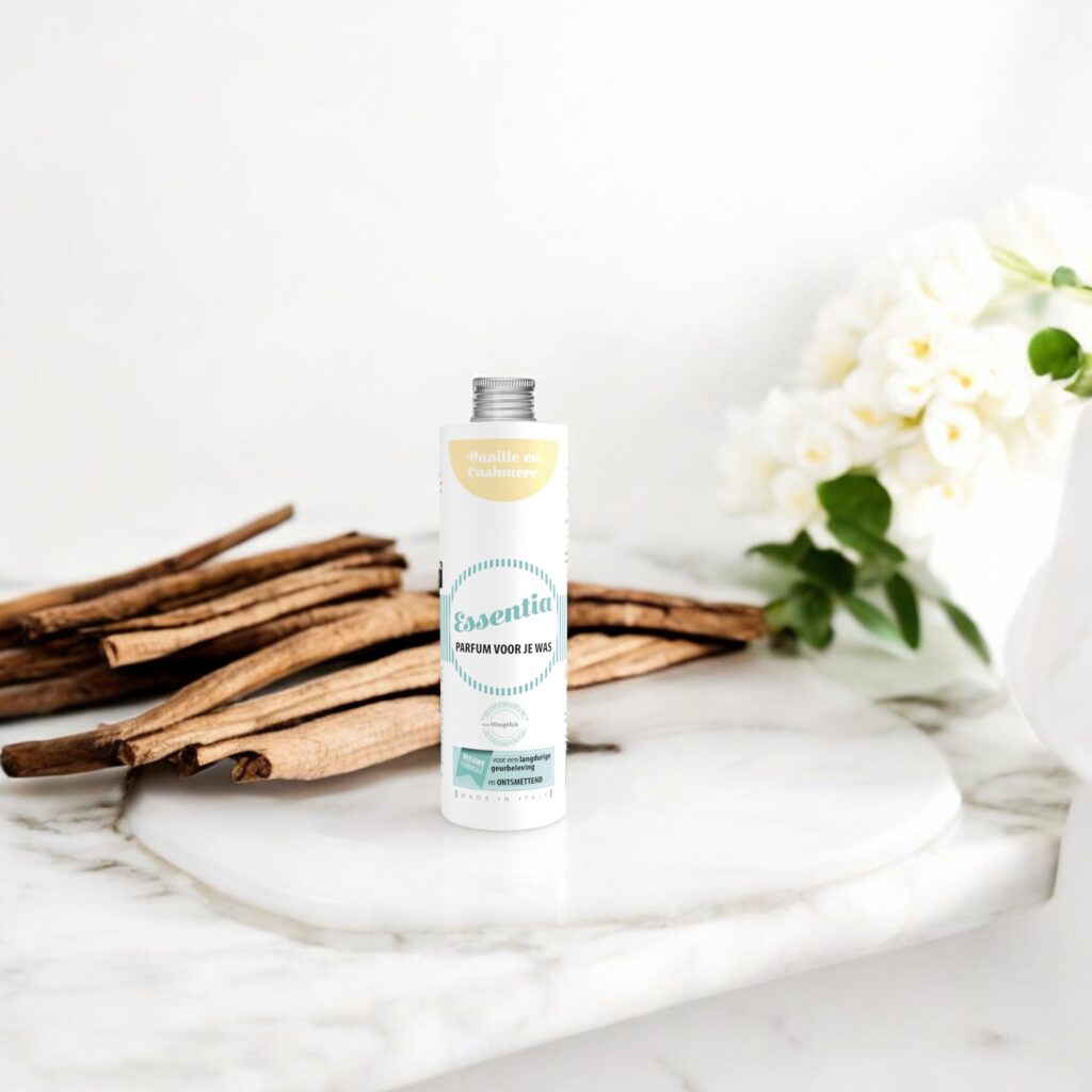 Essentia Wasparfum Vanille en Cashmere staat op een marmeren oppervlak tussen kaneelstokjes en witte bloemen en zorgt zo voor een elegante sfeer.