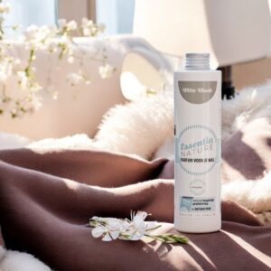 Essentia Wasparfum Witte Musk 250 ml staat op een gezellig bruin-beige deken met witte bloemen en zacht zonlicht in de kamer.