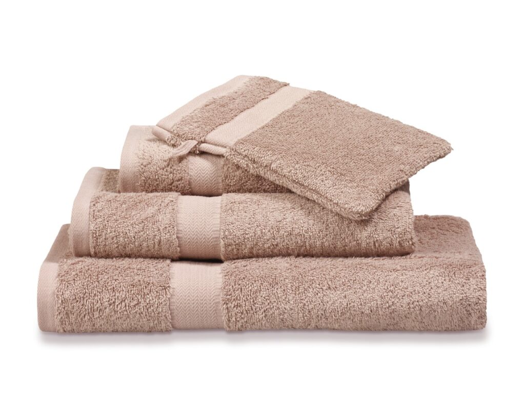 De Vandyck Prestige-handdoekenset in Blush bestaat uit een keurig gestapelde set van zes beige handdoeken in verschillende maten.
