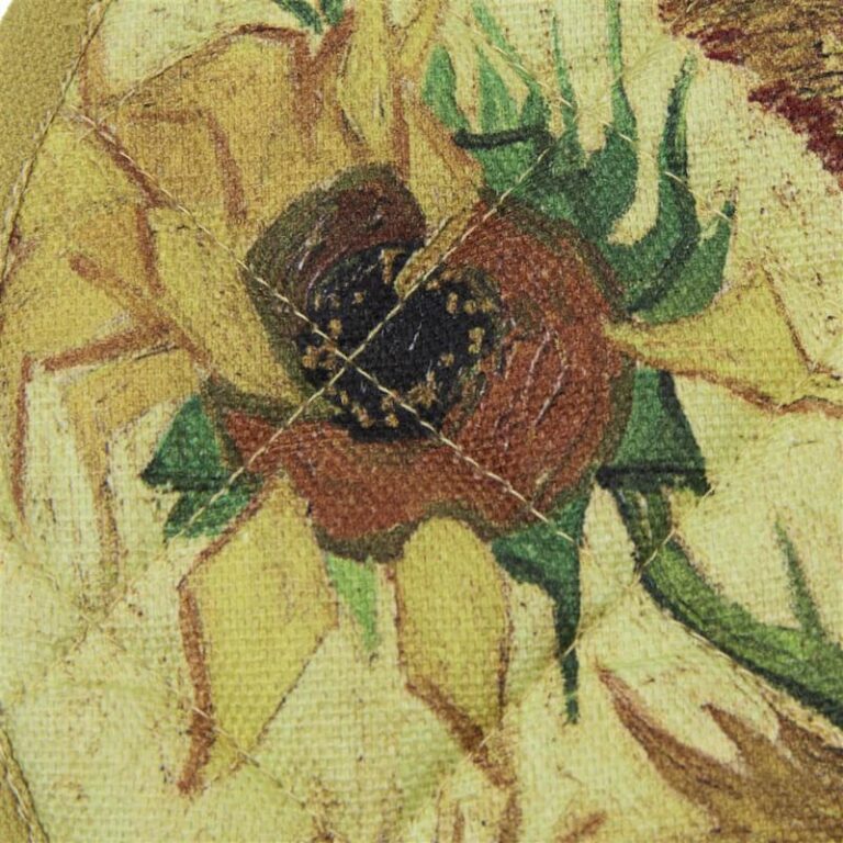 Deze close-up toont de gewatteerde stof van Merkaanbod Badgoed.com met een geschilderd zonnebloemmotief in geel, groen en bruin en zichtbare stiknaden over het reliëf.